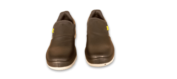 Par de zapatos de seguridad GamaX de color negro, con diseño sin cordones y suela blanca, vistos de frente.