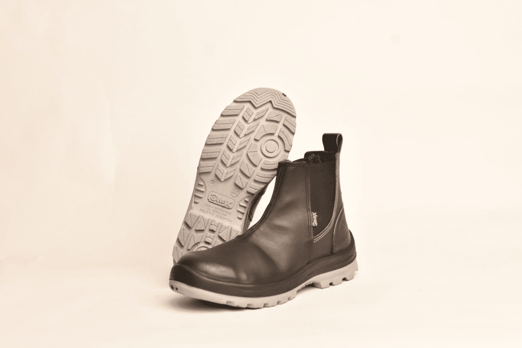 Par de botines de seguridad GamaX, modelo 108A-118P, en color negro, con un botín mostrando la suela de protección antideslizante.